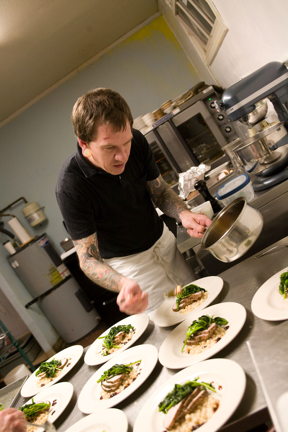 Chef Aaron Solley at James John Cafe setting course plates out in kitchen