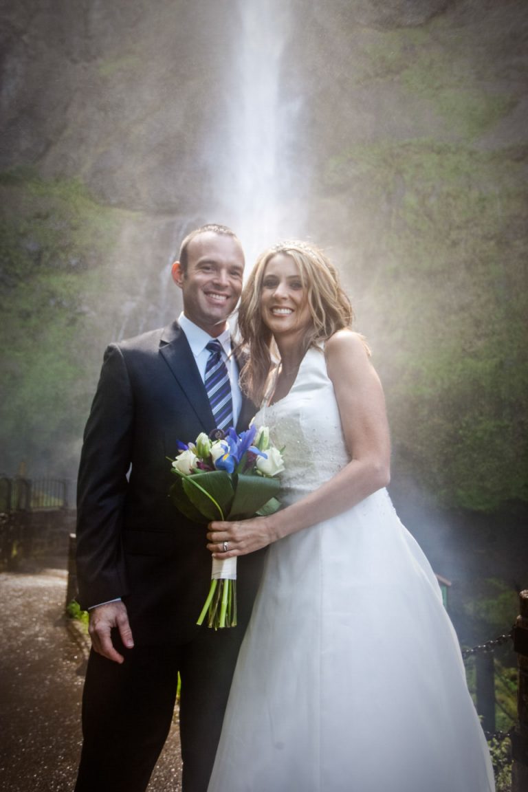 Bride and Groom standing in front of Multnomah Falls