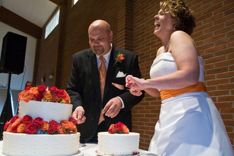 Brid and  groom laugh during portland wedding cake cutting